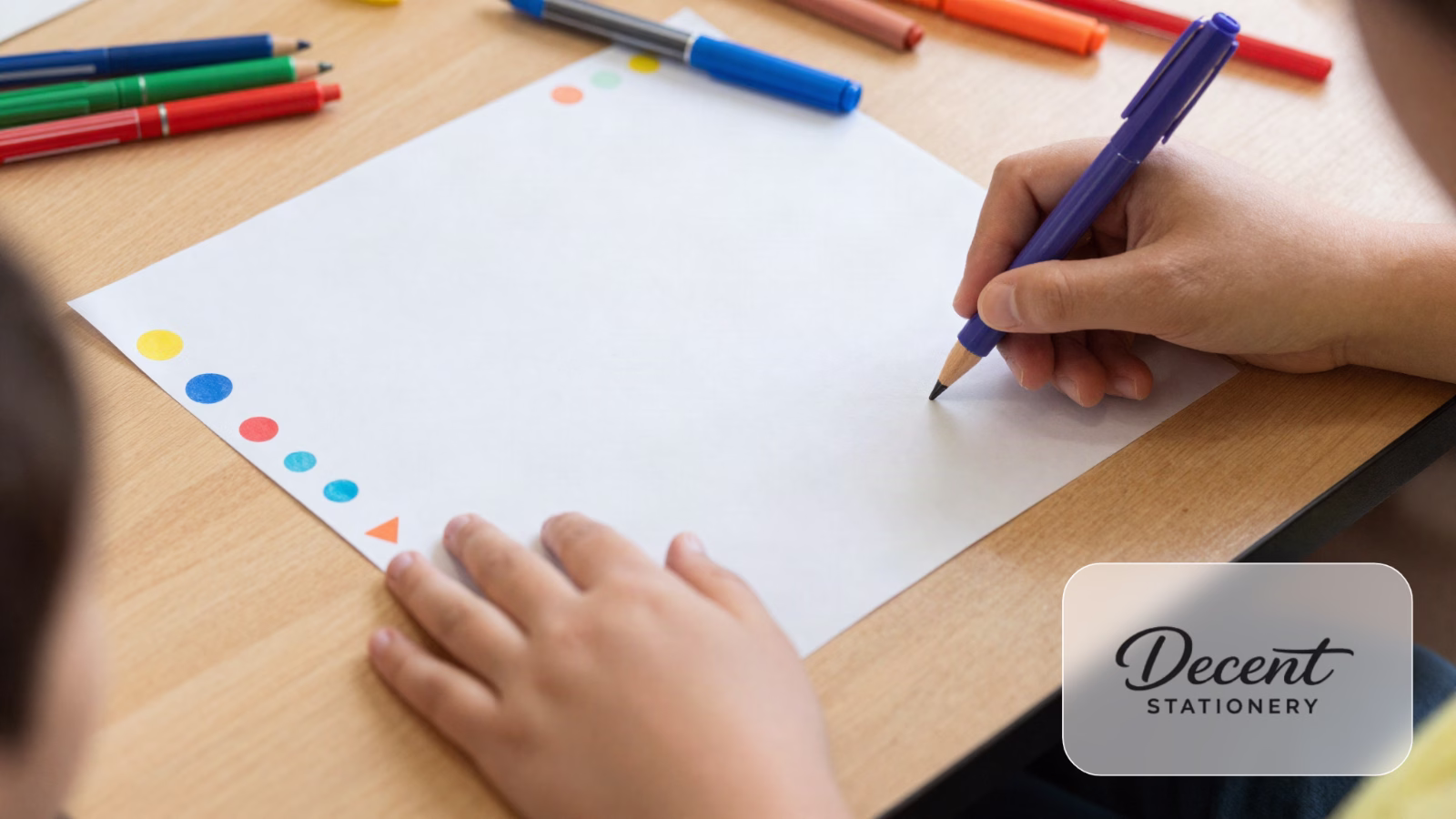 Kids hands decorating the border of a chart paper with sketch pens