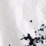 Black ink splatter on crumpled white paper, Decent Stationery